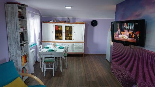 a dining room with a table and a tv on a wall at Vila Largo 