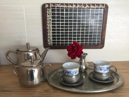 a tray with three tea pots and cups on a table at Stillvoll Wohnen mit Fahrradweg zum Festspielhaus in Heinersreuth