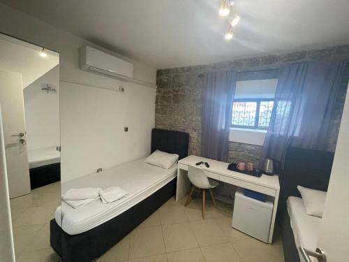 een kleine kamer met een bed en een bureau bij Rooms Pama in Split
