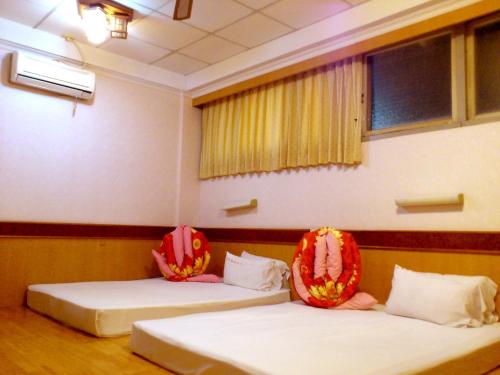 2 camas en una habitación con en Jin Lon Hotel, en Taitung