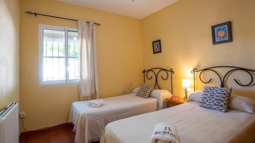 a room with two beds and a window at Casa Campo Chimenea Rincón de la Victoria by Ruralidays in Rincón de la Victoria