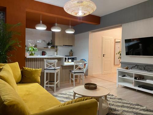 a living room with a yellow couch and a kitchen at JAY's Park Place in Cluj-Napoca