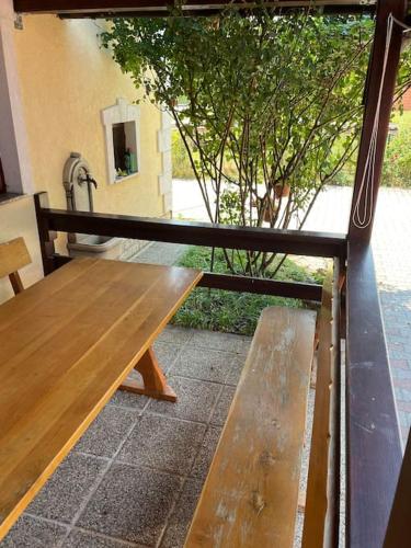 a wooden bench sitting on top of a porch at Room in Otočac HELENA in Otočac