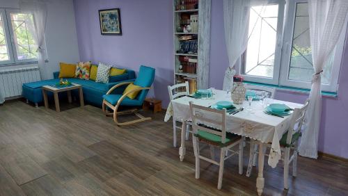 a living room with a table and a blue couch at Vila Largo in Donja Mala