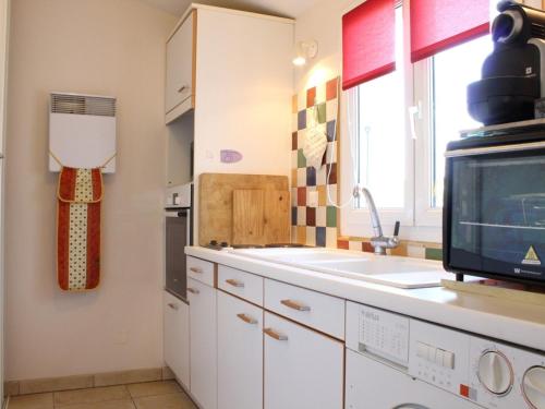 une cuisine avec un évier et un micro-ondes dans l'établissement Maison de standing 6 couchages, jardin clos, garage, proche marché et pistes cyclables – ménage inclus - FR-1-246A-410, à Le Trait dʼUnion