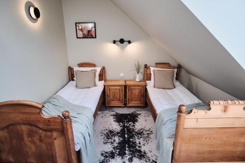 a attic bedroom with two beds and a staircase at Hotel Pernigele in Jelgavkrasti