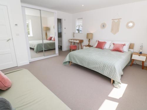 a bedroom with two beds and a mirror at Sandy Cove in Penzance