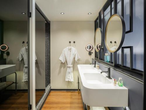 a bathroom with two sinks and a mirror at Novotel Mexico City World Trade Center in Mexico City