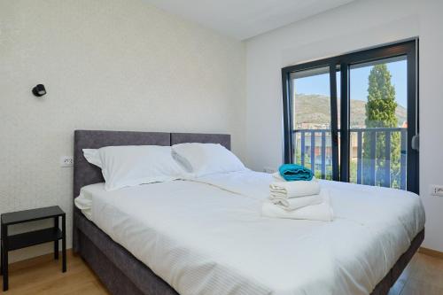 a bedroom with a large white bed with a window at DOMINIUM CITY SUITES in Dubrovnik