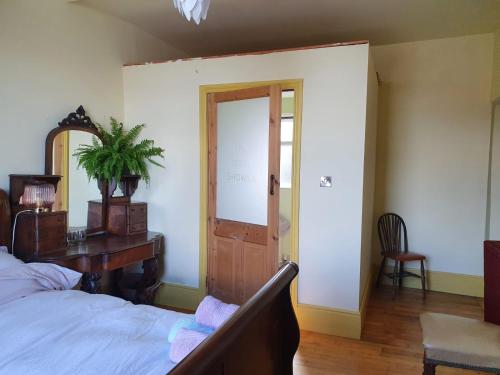 een slaapkamer met een bed, een tafel en een deur bij The exchange buildings in Cork