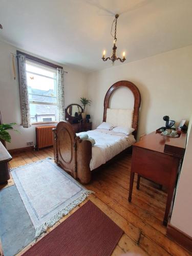 een slaapkamer met een bed, een tafel en een raam bij The exchange buildings in Cork