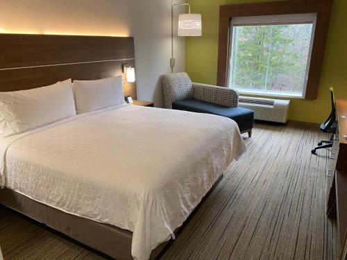 a hotel room with a large bed and a chair at Holiday Inn Express Columbia, an IHG Hotel in Columbia