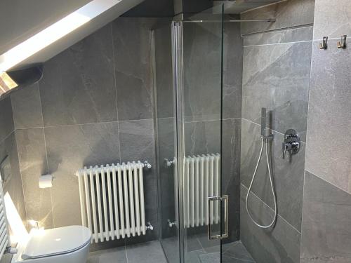 ein Badezimmer mit Glasdusche und Toilette in der Unterkunft Rooftop openspace with balconies parking and bbq in Como
