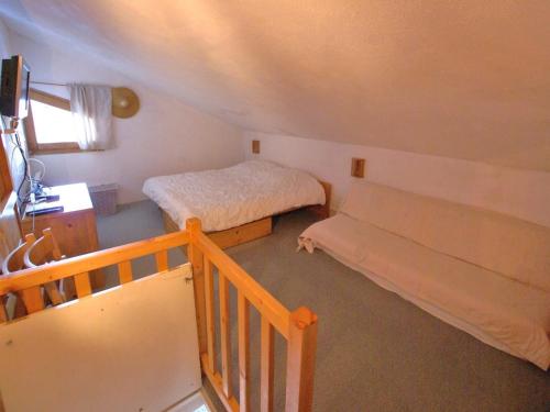 a small room with two beds and a staircase at Studio Enchastrayes, 3 pièces, 6 personnes - FR-1-165A-108 in Enchastrayes