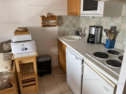 une petite cuisine avec un évier et une cuisinière dans l'établissement Charmant T2 avec balcon, parking à 50m des commerces - FR-1-295-156, aux Angles