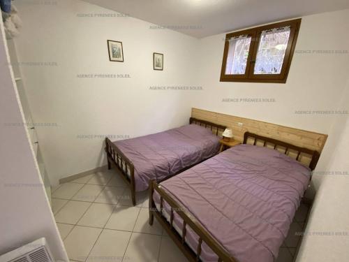 Duas camas num pequeno quarto com uma janela em Appartement Les Angles, 3 pièces, 6 personnes - FR-1-295-157 em Les Angles