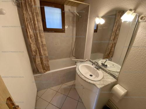 La petite salle de bains est pourvue d'un lavabo et d'une baignoire. dans l'établissement Appartement F3 avec Wi-Fi, parking et terrasse - 6 couchages, proche centre et navette gratuite - FR-1-295-157, aux Angles