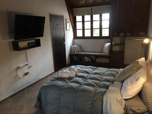 um quarto com uma cama grande e uma televisão em Casa Verde Palmares em Godoy Cruz