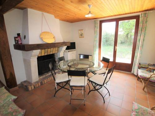 une salle à manger avec une table et des chaises et une cheminée dans l'établissement Maison Calme Proche Mer – 5 Couchages, Jardin, WiFi, Animaux Admis - FR-1-246A-97, à Saint-Georges-dʼOléron