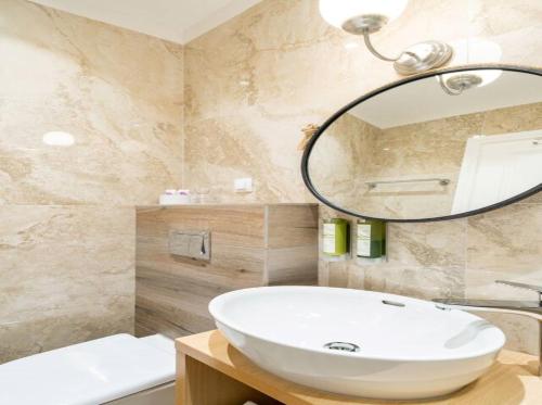 a bathroom with a white sink and a mirror at Villa Joe in Čilipi