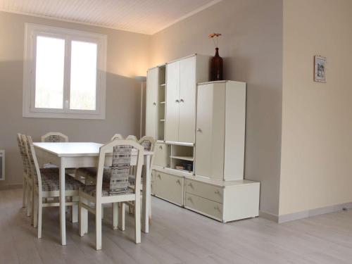 d'une salle à manger avec une table et une armoire blanche. dans l'établissement Maison bord de mer à la Cotinière, 3 chambres, terrasse et parking, 6 couchages - FR-1-246A-101, à Saint-Pierre-dʼOléron