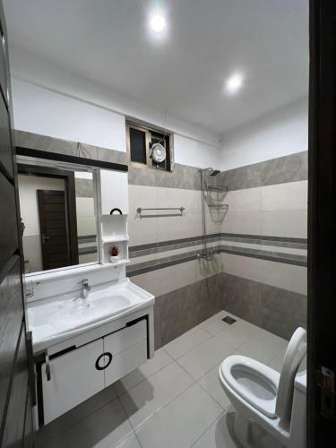 a bathroom with a sink and a toilet and a mirror at Ortus - Murree Hills in Murree