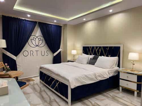 穆里的住宿－Ortus - Murree Hills，一间卧室配有一张特大号床,上面有奥林匹克标志