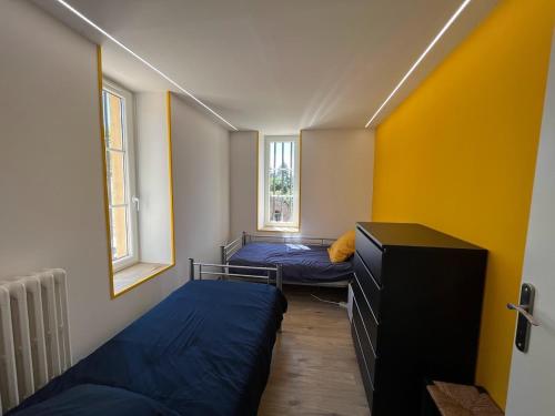 a small room with two beds and two windows at Le Champ Du Possible in Uxeau