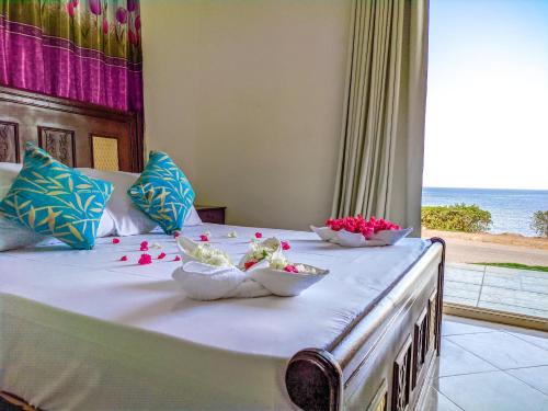 a bed with two bowls of flowers on it at Dahab Bay hotel in Dahab