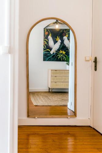a mirror in a room with a wooden floor at Suites Mana - Le Manaloft, Chic et moderne avec salle privée de Fitness en plein centre-ville de Rethel in Rethel