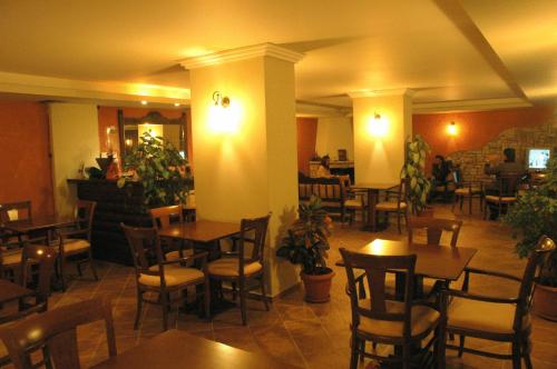 a restaurant with tables and chairs in a room at Aroanios Hotel in Klitoria