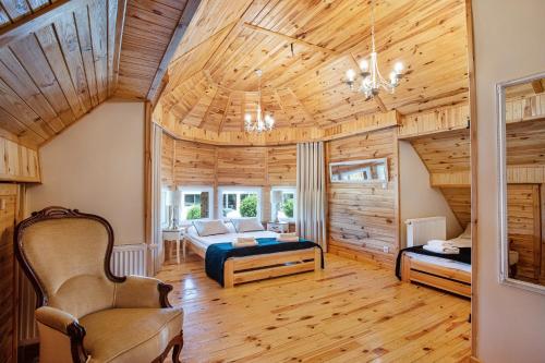 een slaapkamer met een bed in een kamer met houten plafonds bij Skansen Bicz Resort in Stare Miasto