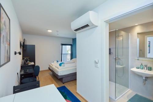 a bathroom with a sink and a bed in a room at DOMINIUM CITY SUITES in Dubrovnik