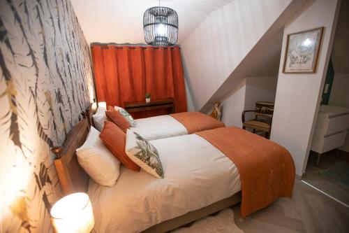 a bedroom with a bed with an orange curtain at Chambre Jungle dans maison d'hote "Le Petit Clouet"- Rochecorbon in Rochecorbon