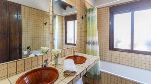 baño con 2 lavabos y espejo grande en Cortijo La Envarra El Borge by Ruralidays, en Moclinejo