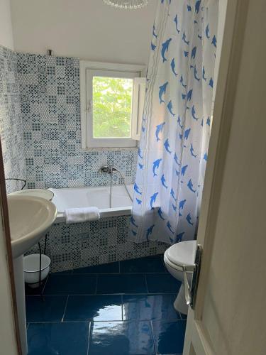 un bagno con lavandino, vasca e WC di Palazzo Porta a Procida