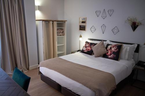 a bedroom with a large bed with pillows on it at Hotel Cruzeiro in Angra do Heroísmo