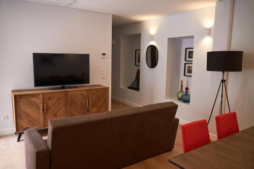 a living room with a couch and a flat screen tv at Hotel Cruzeiro in Angra do Heroísmo