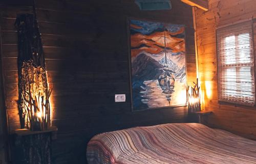a bedroom with a bed and a painting on the wall at COEMBOTA Cabañas in Tigre