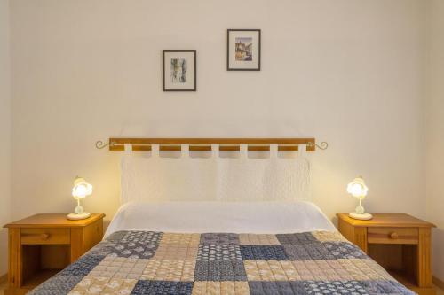 a bedroom with a bed with two lamps on tables at Logis de l'Orme in La Rochepot