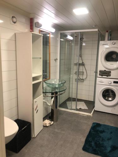 a bathroom with a washing machine and a glass table at Basement Apartment Varadero in Lyngdal