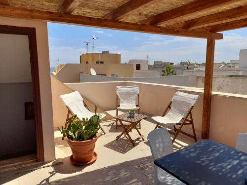 a balcony with chairs and a plant on a roof at Casa Clio in Favignana