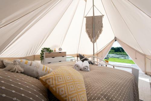 a bedroom with a bed in a tent at Glempings Laimes Taure in Vabole