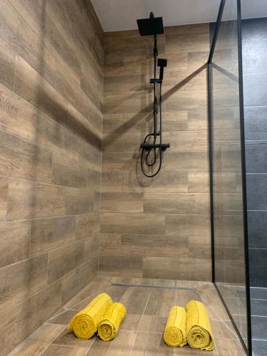 a shower with yellow rubber slippers in a bathroom at Czarny Koń „Black Horse” in Kamienna Góra