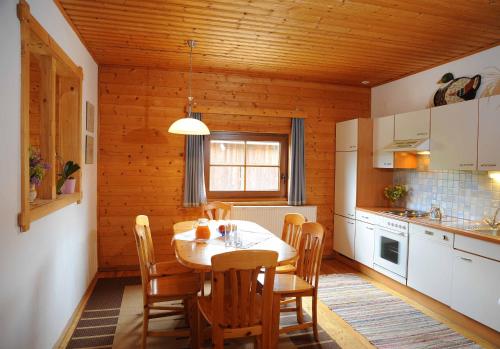 uma cozinha com mesa e cadeiras num quarto em Ferienhof Haberzettl 