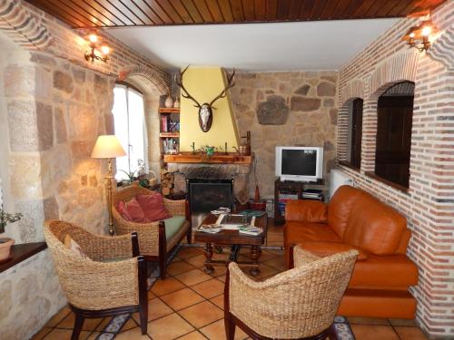 a living room with a couch and chairs and a tv at Casa Rural del Médico in Hontoria del Pinar