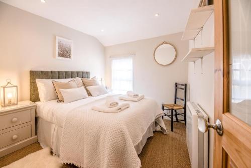 a bedroom with a bed with two towels on it at Holly Cottage in Bury Saint Edmunds