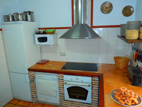 a kitchen with a white stove and a refrigerator at Casa Rural del Médico in Hontoria del Pinar