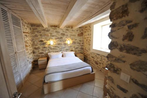 a bedroom with a bed in a stone wall at La Bastide du Soleil in Cannes