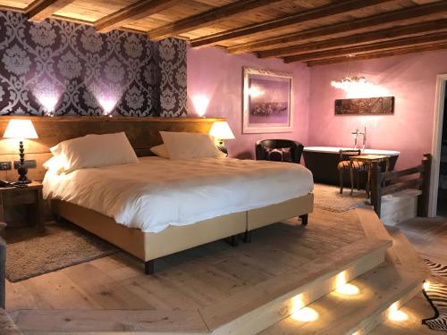 - une chambre avec un grand lit, une table et un bureau dans l'établissement Relais du Chateau Blanc, à La Thuile